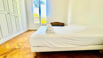 a white bed with towels on it in a room at Sublime 2 bedroom spacious and bright AC Private parking in Nice