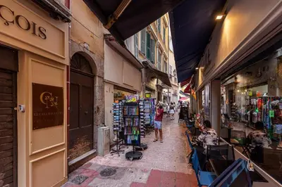 a group of people walking down a street with shops at Appartement rénové Vieux Nice in Nice