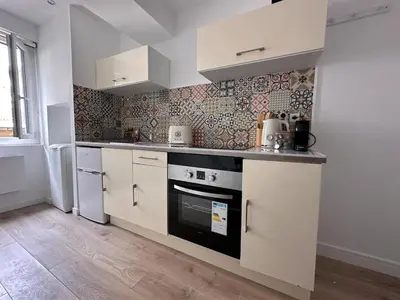 a kitchen with white cabinets and a stove top oven at Appartement rénové Vieux Nice in Nice