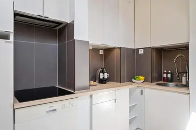 a kitchen with white cabinets and stainless steel appliances at Charme et confort - Nice Centre Libération in Nice