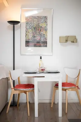 a white table with two chairs and a painting at Charme et confort - Nice Centre Libération in Nice