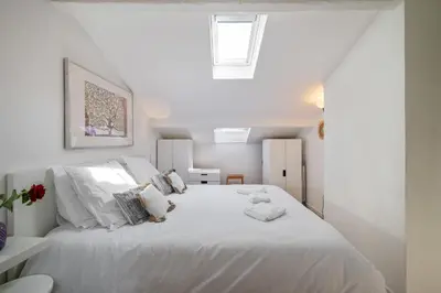 a white bedroom with a large white bed with pillows at Charme et confort - Nice Centre Libération in Nice