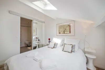 a white bedroom with a large white bed with pillows at Charme et confort - Nice Centre Libération in Nice