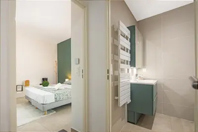 a small bedroom with a bed and a bathroom at Appartement neuf - Patio intérieur - Parking - EF in Èze