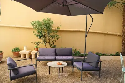 a patio with a couch and chairs and an umbrella at Close to sea center apartment 130m2 in Nice