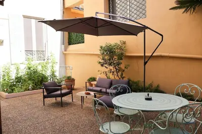 a patio with a table and chairs and an umbrella at Close to sea center apartment 130m2 in Nice