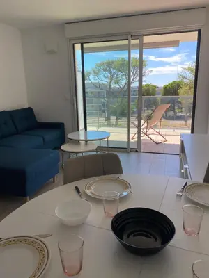a living room with a table with plates on it at New flat with swimming pool on rooftop in Saint-Laurent-du-Var