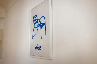 a white sign with blue writing on a wall at Plage et Salsa, Nice Promenade des anglais in Nice