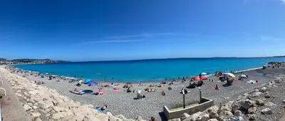 a group of people on a beach near the water at Plage et Salsa, Nice Promenade des anglais in Nice