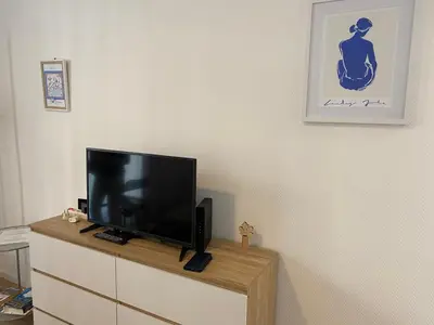 a flat screen tv sitting on top of a dresser at Plage et Salsa, Nice Promenade des anglais in Nice