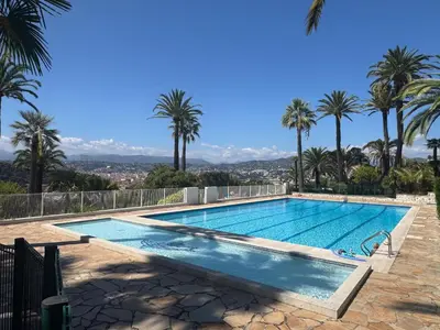 a swimming pool with palm trees in the background at MONT BORON PALMS AP4480 by Riviera Holiday Homes in Nice