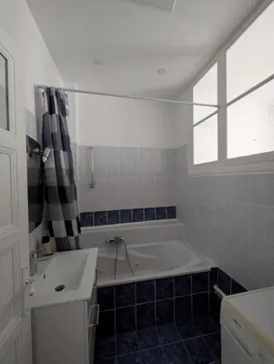 a bathroom with a tub and a sink and a window at Bel appartement proche centre 15 minutes in Nice