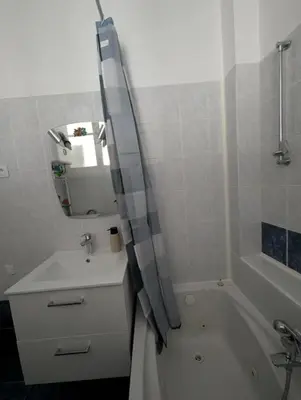 a bathroom with a sink and a tub and a mirror at Bel appartement proche centre 15 minutes in Nice