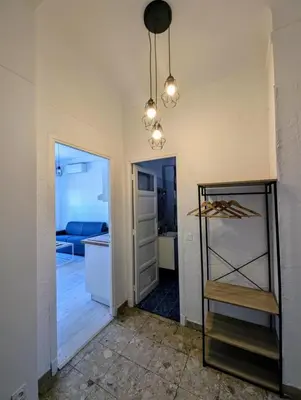 a room with a kitchen and a hallway with a table at Bel appartement proche centre 15 minutes in Nice
