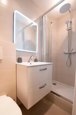 a white bathroom with a sink and a shower at Studio Place Masséna in Nice