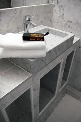a book sitting on top of a bathroom sink at Hôtel & Appartements Monsigny in Nice