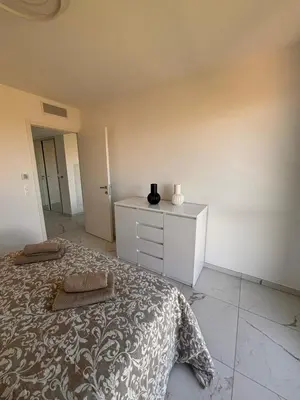 a bedroom with a bed and a dresser in it at SEASIDE VIEW Saint Laurent in Saint-Laurent-du-Var