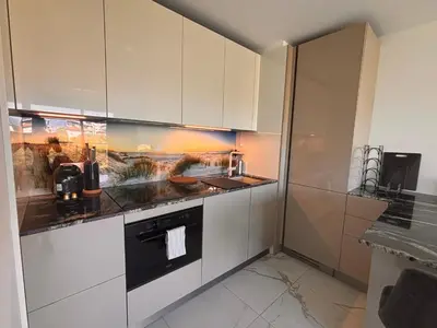 a kitchen with white cabinets and a black oven at SEASIDE VIEW Saint Laurent in Saint-Laurent-du-Var