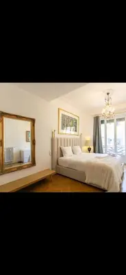 a bedroom with a large bed and a mirror at Le Grand Bourgeois à Nice in Nice