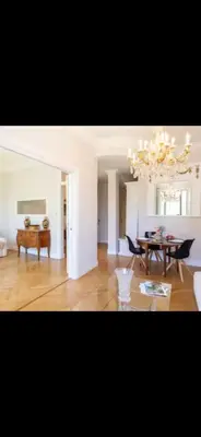 a living room with a dining table and a chandelier at Le Grand Bourgeois à Nice in Nice