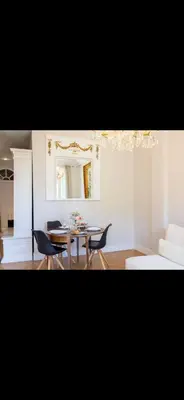 a living room with a table and chairs and a mirror at Le Grand Bourgeois à Nice in Nice