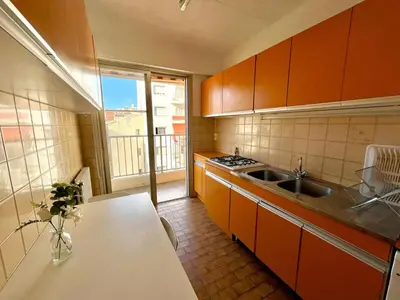 a small kitchen with orange cabinets and a sink at Beautiful 2 bedroom apartment Port - 5 min to beaches in Nice
