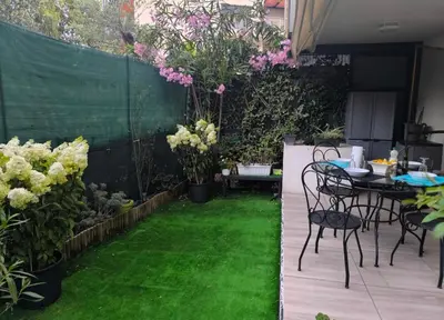 a patio with a table and chairs and flowers at 1 Chambre pour 2 personnes in Nice