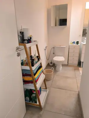 a bathroom with a toilet and a shelf with towels at 1 Chambre pour 2 personnes in Nice