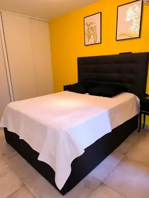 a bedroom with a large bed in a yellow wall at 1 Chambre pour 2 personnes in Nice