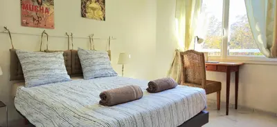 a bedroom with a bed and a desk and a window at Spacious 3 room close to tram and amenities in Nice