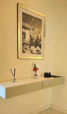 a shelf in a room with a picture on the wall at Spacious 3 room close to tram and amenities in Nice