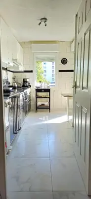 a large kitchen with white tile floors and a window at Spacious 3 room close to tram and amenities in Nice