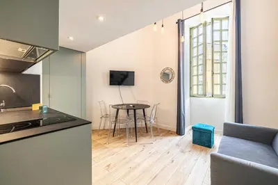 a kitchen and a living room with a table at Residence Garibaldi - Nice in Nice