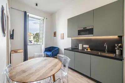 a kitchen with a wooden table in a room at Residence Garibaldi - Nice in Nice