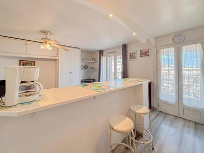 a kitchen with a counter and stools in a room at Douceur azuréenne - Wifi, Parking, vue mer, 4pers in Nice