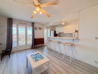 a living room with a ceiling fan and a kitchen at Douceur azuréenne - Wifi, Parking, vue mer, 4pers in Nice