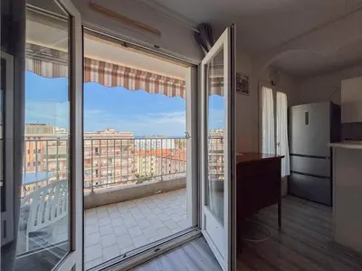 a room with a balcony with a view of a city at Douceur azuréenne - Wifi, Parking, vue mer, 4pers in Nice