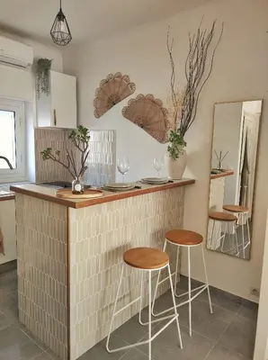 a kitchen with two stools and a counter with mirrors at Studio Jungle Bohème - à 3 min de la Promenade des anglais à pieds in Nice