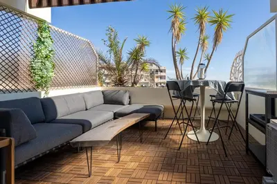 a living room with a couch and a table on a balcony at Azzuro - Mare e Terrazza in Nice