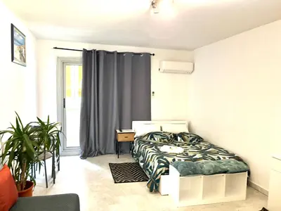 a bedroom with a bed and a desk and a window at Studio Californie in Nice