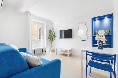 a living room with a blue couch and a table at Nice Renting - 6C FRANCE - Chic Stay Pedestrian Zone Sea Massena in Nice