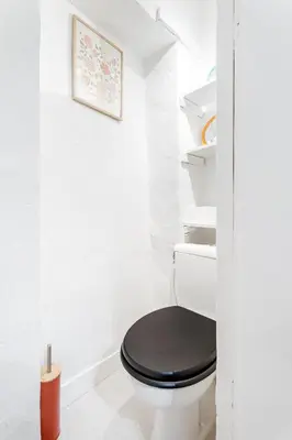 a bathroom with a toilet with a black seat at Nice Renting - 6C FRANCE - Chic Stay Pedestrian Zone Sea Massena in Nice