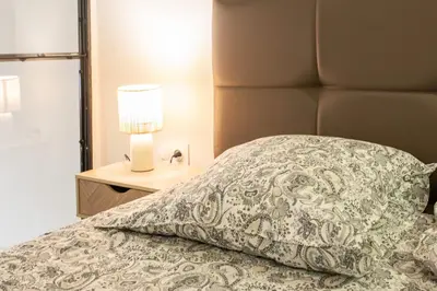 a bed with a pillow and a lamp on a night stand at Duplex cosy dans la Vieille Ville in Nice
