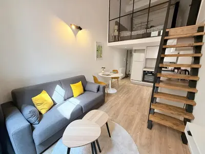a living room with a blue couch and a loft at Duplex cosy dans la Vieille Ville in Nice