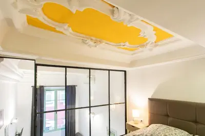 a bedroom with a bed and a yellow ceiling at Duplex cosy dans la Vieille Ville in Nice