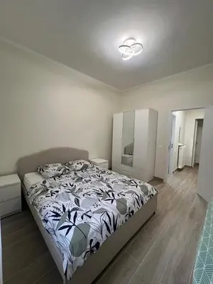 a bedroom with a bed with a black and white comforter at Superbe appart près de la mer in Nice