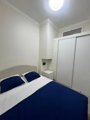 a white bedroom with a blue and white bed at Superbe appart près de la mer in Nice