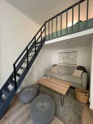 a living room with a couch and a staircase at Studio proche gare in Nice