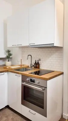 a kitchen with white cabinets and a stainless steel oven at Carre d'OR Massena luxury apartment in Nice