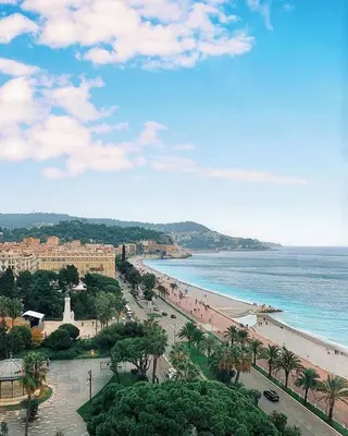 a view of a beach with palm trees and the ocean at Carre d'OR Massena luxury apartment in Nice